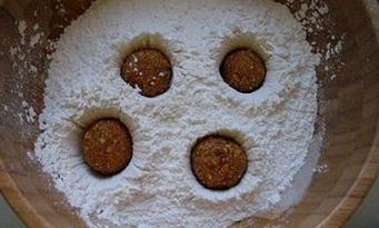 4、花生糖馅元宵,准备一盆清水，一个漏网，一盆糯米粉，将花生馅再次搓圆，放入糯米粉盆内