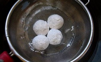 5、花生糖馅元宵,摇晃盆，使花生馅均匀的沾满糯米粉，将沾满糯米粉的小球放在漏网上，在清水盆里浸泡，默数5秒