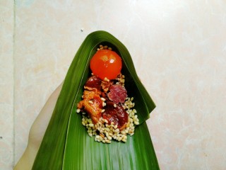 16、五花肉咸蛋黄腊肠粽,均匀摆放好蛋黄，五花肉和腊肠