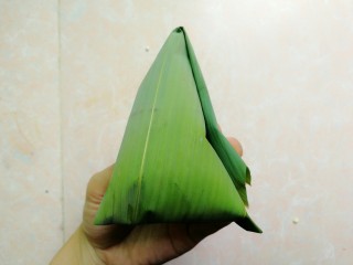 19、五花肉咸蛋黄腊肠粽,把多余的粽叶折回来，如图