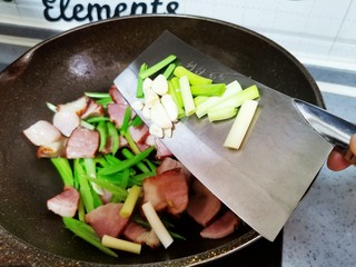14、芹菜炒腊肉,倒入蒜片和蒜苗翻炒均匀