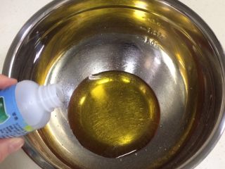 1、蔓越莓椰蓉月饼,在盆内倒入转化糖浆和枧水，用手动打蛋器搅拌均匀。