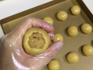 17、蔓越莓椰蓉月饼,用手的虎口位置，把饼皮四周向上推，边推边收口。