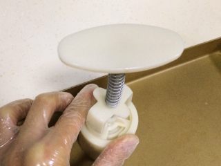 22、蔓越莓椰蓉月饼,倒扣在不沾烤盘内，力道均衡的向下按压。