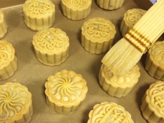 25、蔓越莓椰蓉月饼,取出月饼，给月饼表面刷上一层薄薄的蛋黄水。