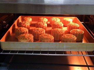 26、蔓越莓椰蓉月饼,继续送入预热好的烤箱中层，180度15分钟，注意观察上色情况，待上色后可以盖锡纸。