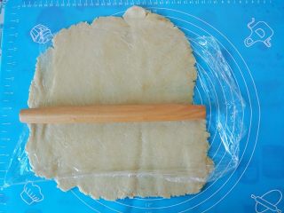 13、蜂蜜焦糖核桃派,把派皮从冰箱里拿出来，用擀面杖擀开，薄厚均匀，可以拿起来用手撑开看看