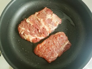 8、照烧猪排,放入腌制好的猪排煎制。