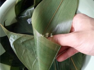8、口口鲜肉粽,取一片粽叶,如图操作,将粽叶卷成漏斗状;