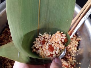 9、口口鲜肉粽,放入糯米肉块,用勺子压紧实;继续填入糯米肉块,直至9分满;