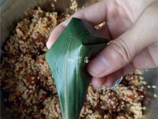 11、口口鲜肉粽,如图所示,将顶部的粽叶也压下来;