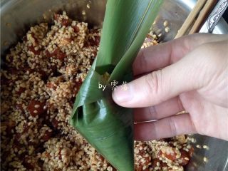 10、口口鲜肉粽,如图所示,将粽叶尖部压下来;
