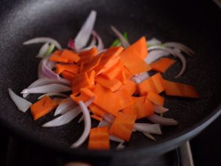 7、【韩剧美食做起来】の辣炒年糕,洋葱微微变软后,加入胡萝卜,继续不断翻炒