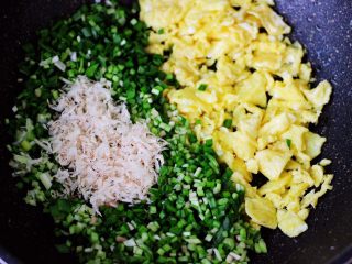 6、薄皮韭菜鸡蛋包,把切碎的韭菜和葱，放入炒鸡蛋的锅里。