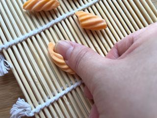 11、多彩麻食,把小块面团放在寿司帘上，用大拇指摁压，往前搓至卷起即可