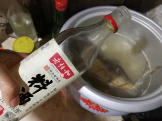 10、粉葛鲮鱼汤,倒入约3勺料酒。