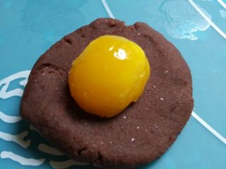 7、豆沙蛋黄月饼,如图先取一豆沙包住蛋黄揉圆