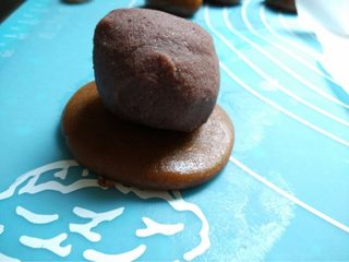 8、豆沙蛋黄月饼,如图再将面团按扁放入豆沙蛋黄馅儿包好揉圆