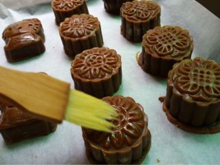 13、豆沙蛋黄月饼,如图烤箱预热，将月饼先刷一层水，放入180度先烤5分钟定型，拿出放凉一下刷蛋液水（蛋黄一个蛋清少量拌匀）