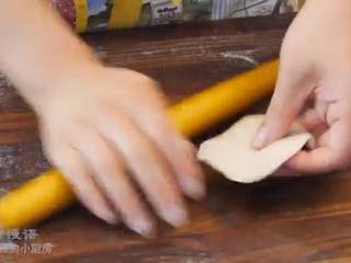 12、酥皮鲜肉月饼,取一个酥皮面卷，把两头往中间窝，按扁，擀一擀