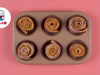 4、土豆培根玫瑰花卷,卷好后摆入烤盘，放入预热好200℃的烤箱烤约40分钟