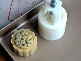 13、豆沙蛋黄月饼,将包好的月饼放入50克的月饼模中，轻轻一压，月饼的雏形就有了。