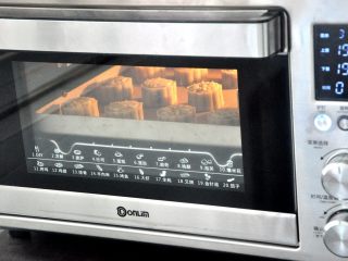 15、豆沙蛋黄月饼,放入烤箱烤5分钟给月饼定型，取出给月饼刷一层薄薄的蛋黄水，一定要很薄，切忌贪多，刷完后再放入烤箱烤15分钟，表面上色即可。（各家烤箱温度不一