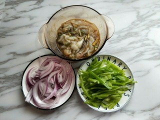 10、#做妈妈的拿手菜#爆炒鱿鱼,我们利用这个时间来切配菜,把洋葱去皮,切丝,我只用了半个洋葱,量可以根据自己喜欢增加,青椒洗干净,去根,去籽再切丝。准备工作完成。