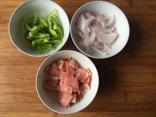 2、双酱培根披萨,面团发酵的时候我们就可以来准备馅料啦：洋葱、青椒切成丝，培根切小块；