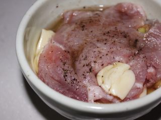 4、几乎无油的“炸”猪排,然后就开始腌肉了,蒜剥好皮,刀背压一下出汁。姜切薄片。柠檬片也准备好。黑白胡椒都要。味淋也要。没有味淋家里的料酒也可以。