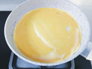 15、腊肠煎饼果子,待面糊凝固之后倒入一半的鸡蛋液