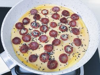 17、腊肠煎饼果子,倒入剩余的鸡蛋液 和黑芝麻