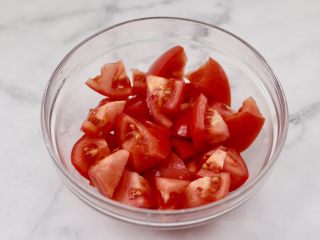 2、茄汁酸汤鸡蛋面,番茄洗净用刀切块。