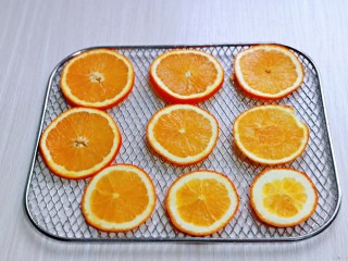 5、自制零添加水果干,切好的橙子片放在烤网上。