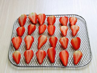 7、自制零添加水果干,草莓从中间切开,一个草莓切两半,也可以根据个人喜欢来切。