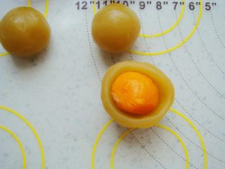 9、广式莲蓉蛋黄月饼,莲蓉馅在手心里按扁，包入一颗咸蛋黄。