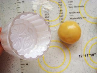 12、广式莲蓉蛋黄月饼,模具里安上喜欢的花片，撒上干面粉，使周围均匀的沾满面粉，再把多余的面粉抖出来。这样在脱模的时候不沾。