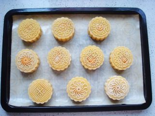 13、广式莲蓉蛋黄月饼,放入饼胚，用手扶着按压，直接脱模到烤盘里。