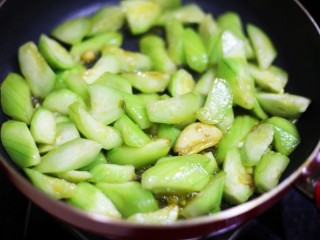 7、鲜掉眉毛的丝瓜豆腐汤,把丝瓜放入锅中翻炒至变色,往锅中倒入清水没过丝瓜烧开。