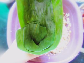 8、五花肉粽,取一片粽叶、折成三角形的漏斗