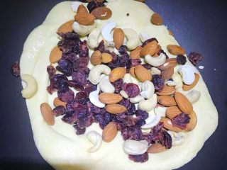 6、多味牛轧糖,把坚果倒入，再次拌匀后就可以关火取出了。坚果不需要切小丁，一会儿我们会将整块的牛轧糖进行切割。