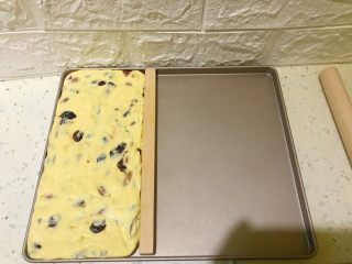 8、多味牛轧糖,稍稍放凉后将牛轧糖取出，放在方形烤盘里。家里如果有大小合适的方形容器，或者牛轧糖专用的塑形工具，都可以用。如果没有，也可以像我一样，借助烤盘将牛轧糖按压成规整的长方体，然后放入冰箱冷藏1小时。