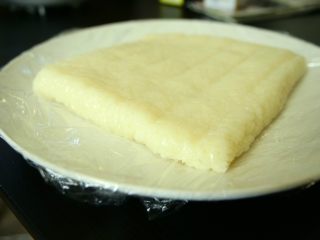 4、红糖糍粑,蒸熟后糯米饭取出碾碎。我是把饭放在袋子里用手揉碎的，中间也用了擀面杖帮忙。不用弄太碎，毕竟糍粑就是要有碎米粒的口感呀。然后把碾碎的米饭平铺在模具里，我用的是饭盒。底下铺了保鲜膜方便取出。上面也用了保鲜膜保湿。