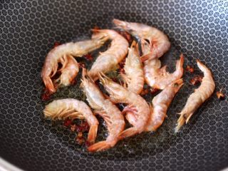 5、绿豆芽炒红虾,锅烧热后，倒入花生油烧热，先小火慢慢炸香，再把腌制好的红虾，放入锅中开始煎制。