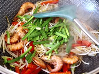12、绿豆芽炒红虾,大火快速翻炒均匀后，加入红椒后韭菜段，煎好的红虾。