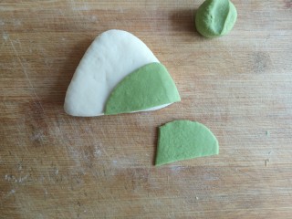 17、粽子饼夹&肉末梅干菜,将牛舌对折（刷油面朝内相对），造型成三角形，用绿色面团造型成粽叶，用水贴在三角形上。