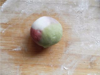 10、天然彩色冰皮月饼,左手按馅的上端，右手虎口转边，将饼皮向上收口，揉圆。