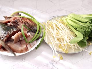 1、炖草鱼,首先备齐所有的食材,草鱼是买的时候,让卖家给片花的,绿豆芽去根洗净,青菜摘洗干净。