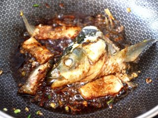 8、炖草鱼,大火翻炒均匀上色。