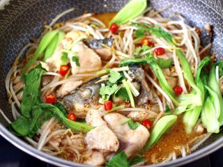 15、炖草鱼,大火烧开后,撒上小米辣和香菜段即可关火。